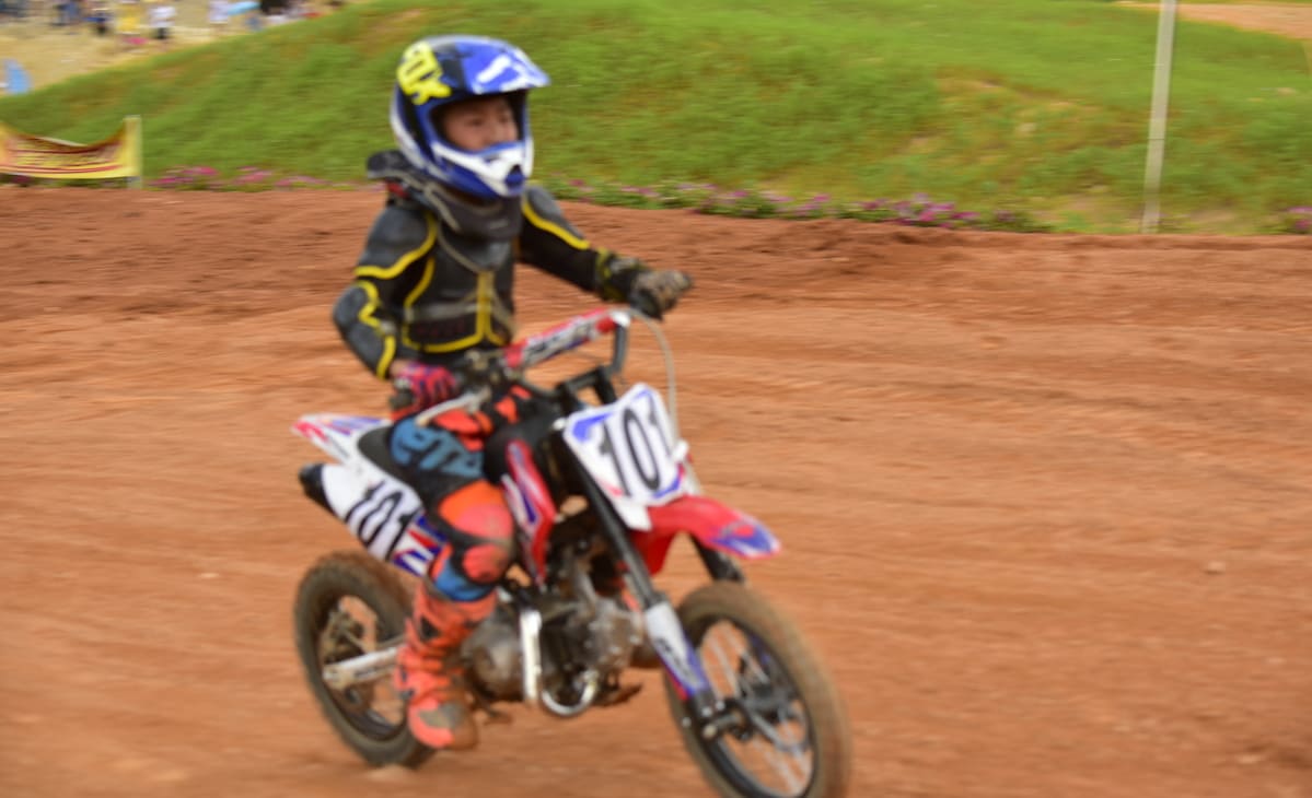 Young Dirt bike rider with full safety equipment in the match